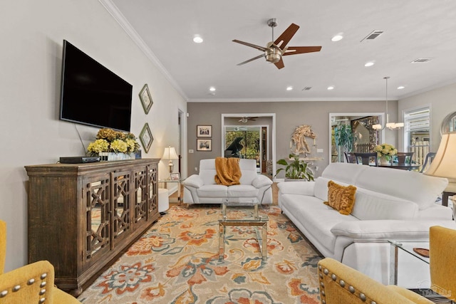 living room featuring ornamental molding, recessed lighting, visible vents, and ceiling fan with notable chandelier