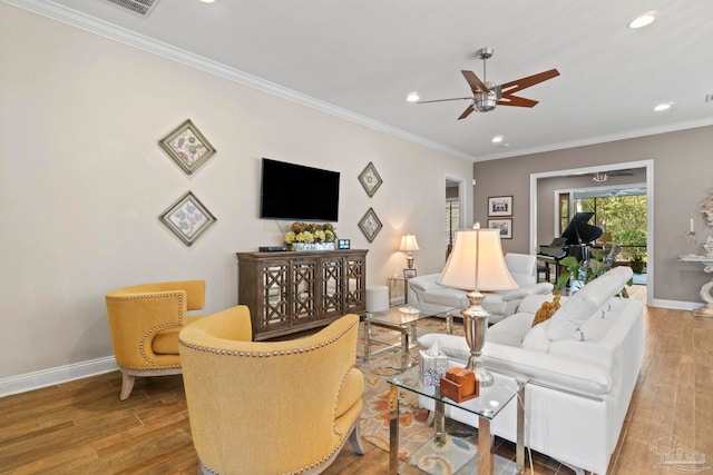 living room with crown molding, wood finished floors, a ceiling fan, and baseboards