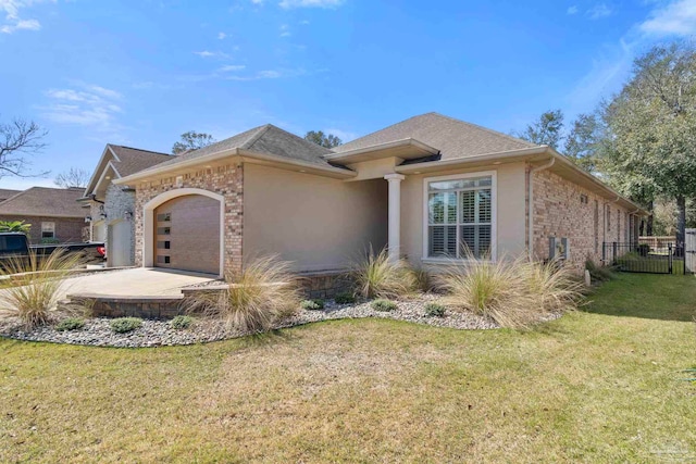 view of front of property with brick siding, stucco siding, an attached garage, fence, and a front lawn