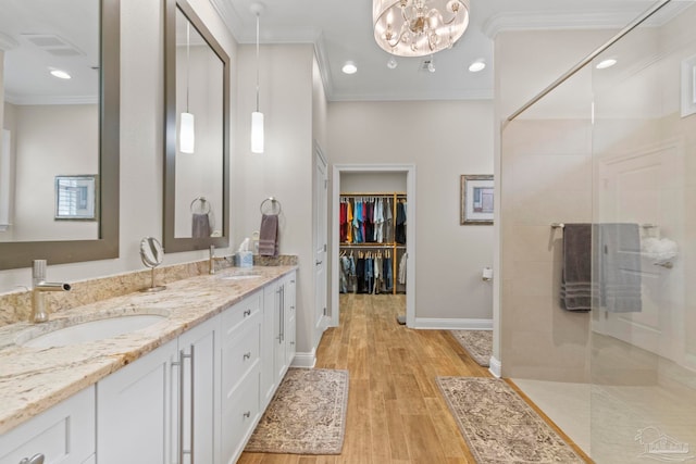 full bath featuring a walk in shower, a sink, and crown molding