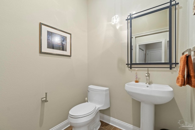 bathroom featuring baseboards and toilet