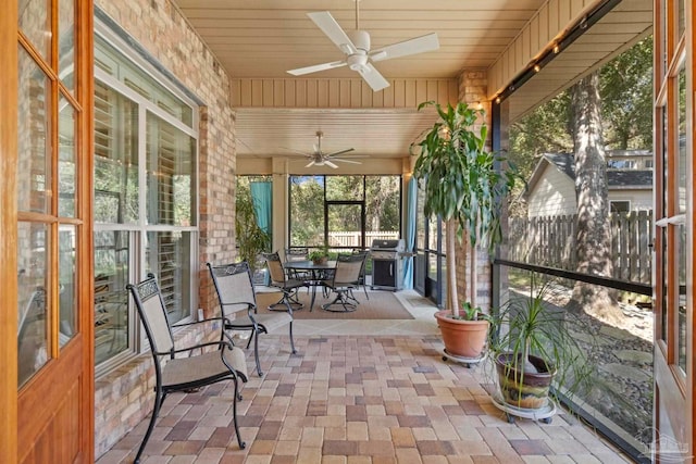 unfurnished sunroom featuring ceiling fan