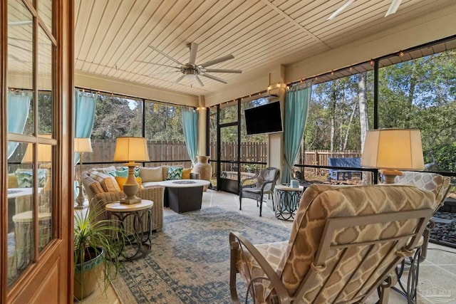 sunroom with plenty of natural light, wood ceiling, and a ceiling fan