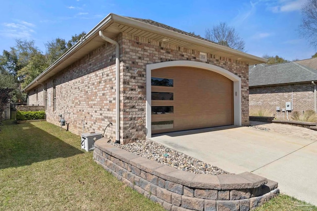 view of side of property with a garage, concrete driveway, brick siding, and a lawn