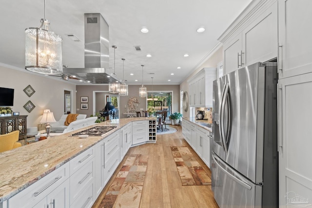 kitchen featuring recessed lighting, island range hood, stainless steel appliances, white cabinetry, and ornamental molding