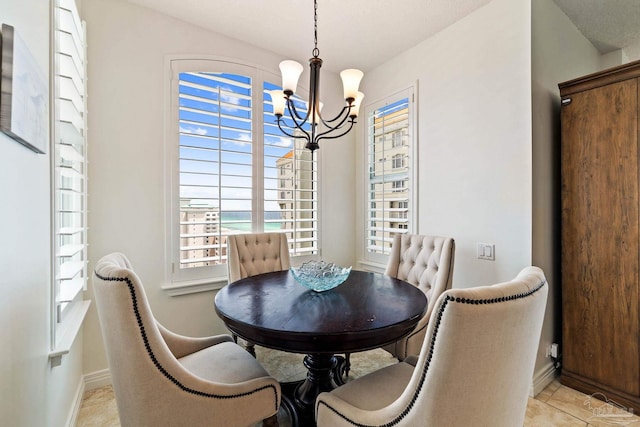 tiled dining room with a chandelier