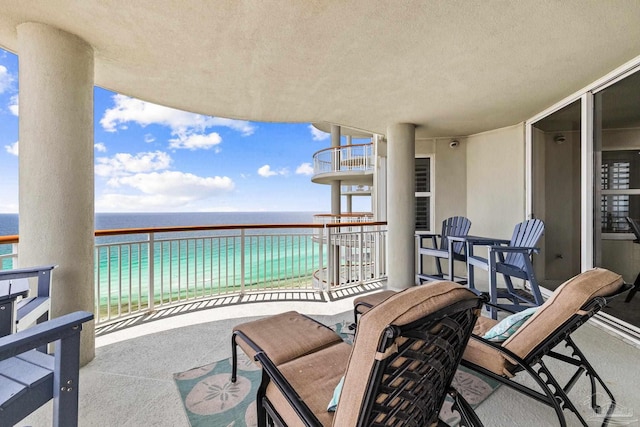 balcony featuring a view of the beach and a water view