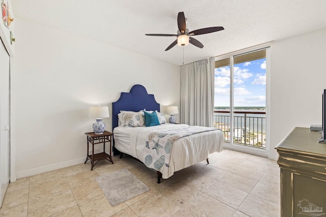 bedroom featuring light tile patterned flooring, ceiling fan, access to outside, and a textured ceiling