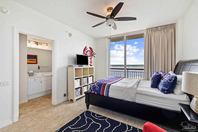 tiled bedroom with a textured ceiling, access to exterior, ensuite bathroom, and ceiling fan