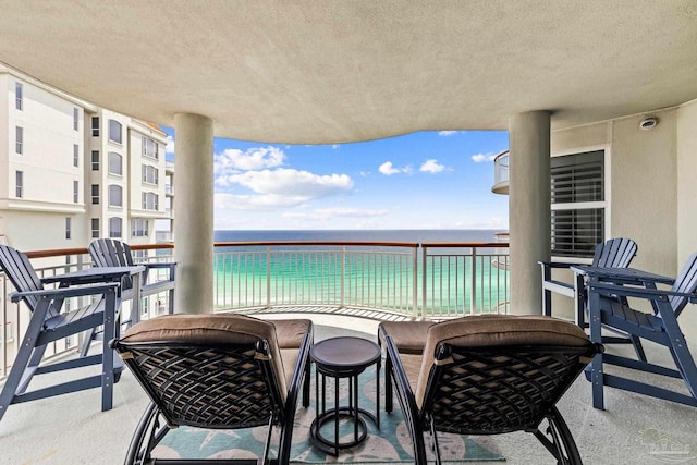 balcony with a water view and a beach view