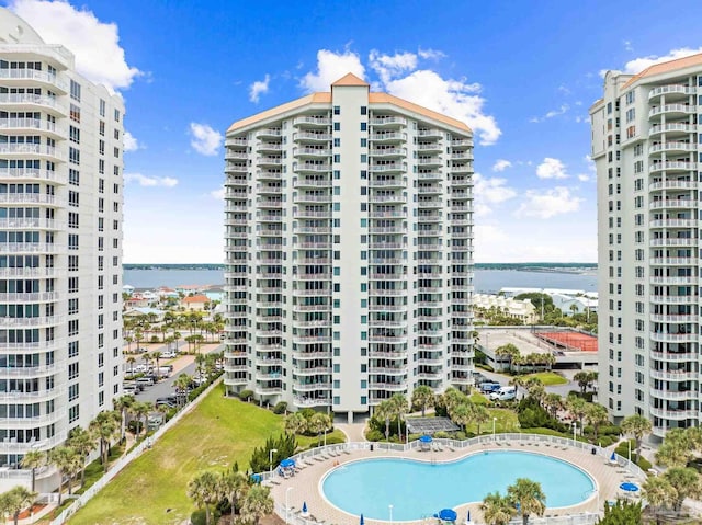 view of property with a community pool and a water view