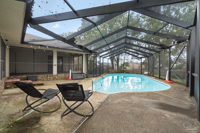 view of swimming pool with glass enclosure and a patio area