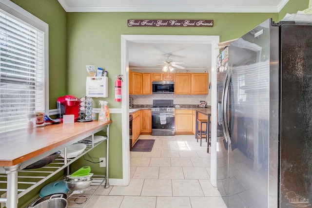 14574 N County Rd 65, Foley, AL 36535 - kitchen with appliances with stainless steel finishes, light tile patterned floors, ornamental molding, light brown cabinetry, and a ceiling fan