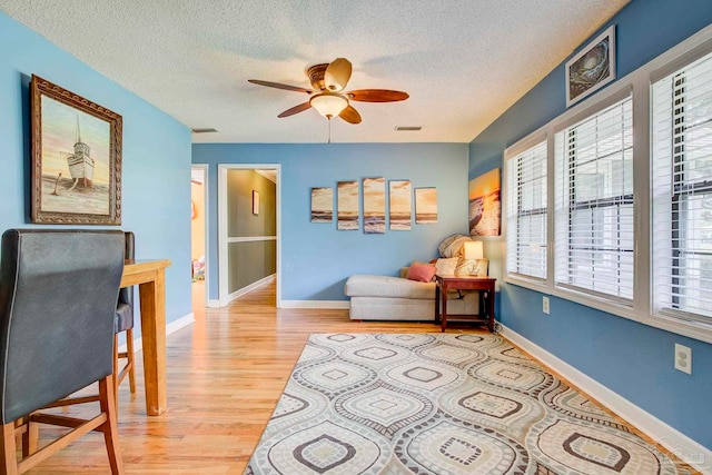 14574 N County Rd 65, Foley, AL 36535 - sitting room featuring light wood-style floors, a ceiling fan, a textured ceiling, and baseboards