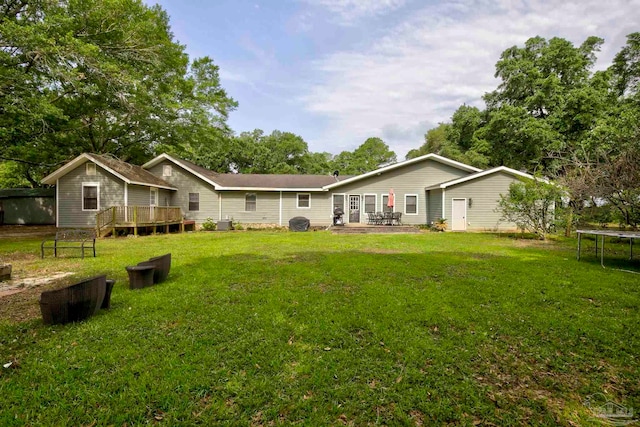 14574 N County Rd 65, Foley, AL 36535 - back of house featuring a trampoline, a yard, and a wooden deck