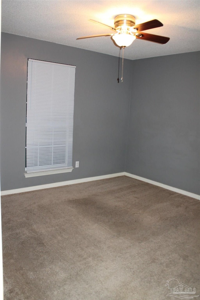 spare room featuring carpet flooring, ceiling fan, and a textured ceiling