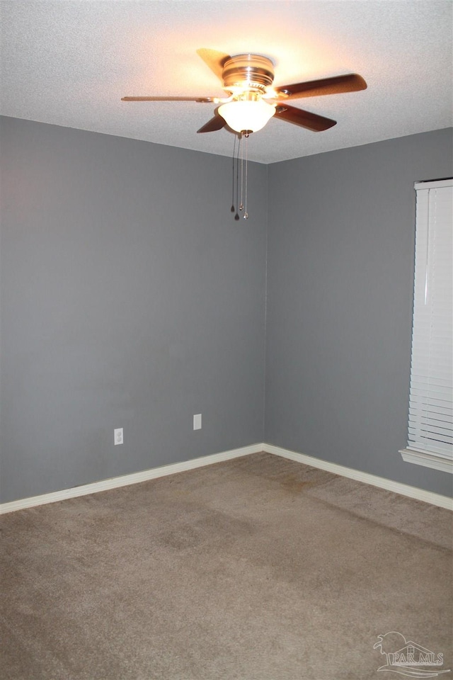 empty room featuring ceiling fan, carpet, and a textured ceiling