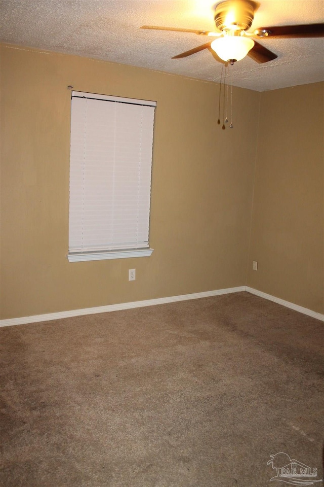 carpeted spare room with ceiling fan and a textured ceiling