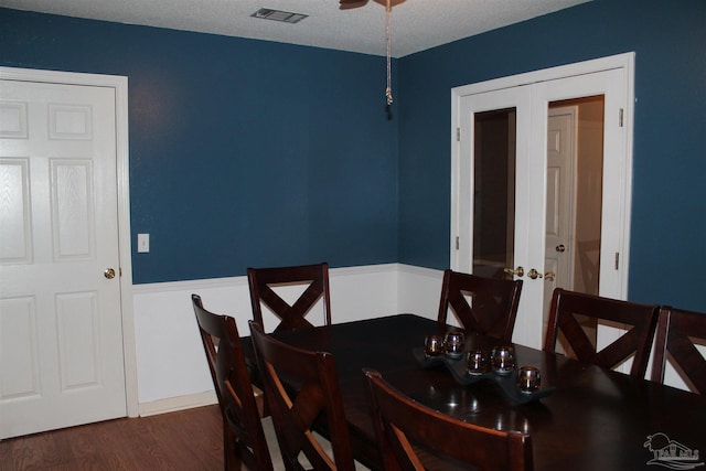 dining area featuring a textured ceiling, french doors, and dark hardwood / wood-style flooring