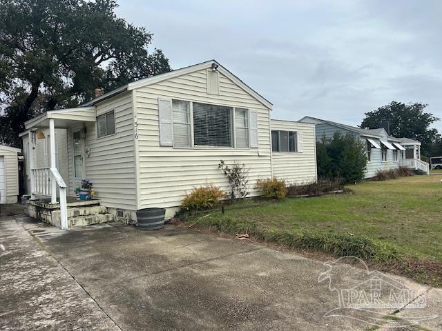 view of front of house with a garage, concrete driveway, and a front lawn