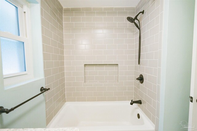 bathroom featuring tiled shower / bath and a healthy amount of sunlight