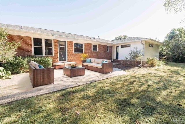 rear view of house featuring outdoor lounge area, a lawn, and a patio