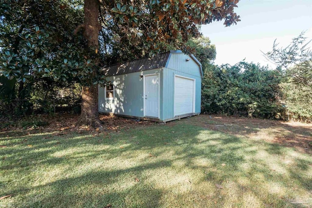 view of outbuilding with a garage and a yard