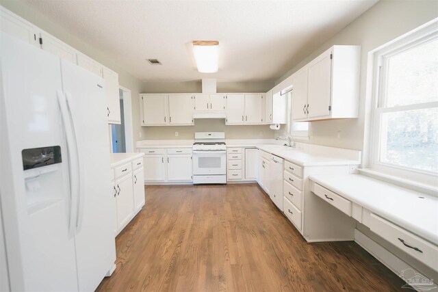 kitchen featuring dark hardwood / wood-style flooring, sink, white appliances, and white cabinetry