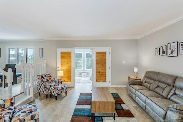 living room featuring a wealth of natural light, crown molding, and light hardwood / wood-style floors