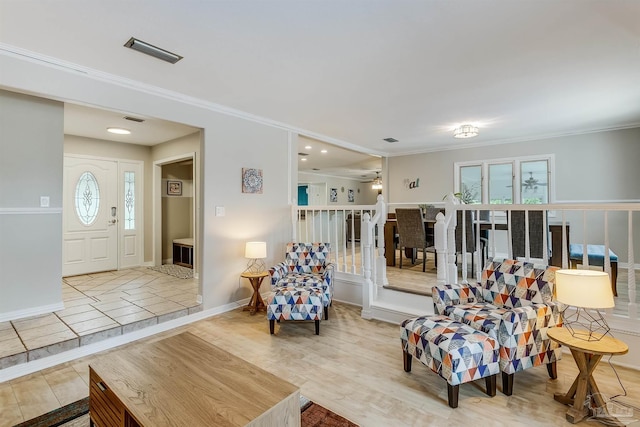 living room featuring ceiling fan, light wood-type flooring, ornamental molding, and a wealth of natural light