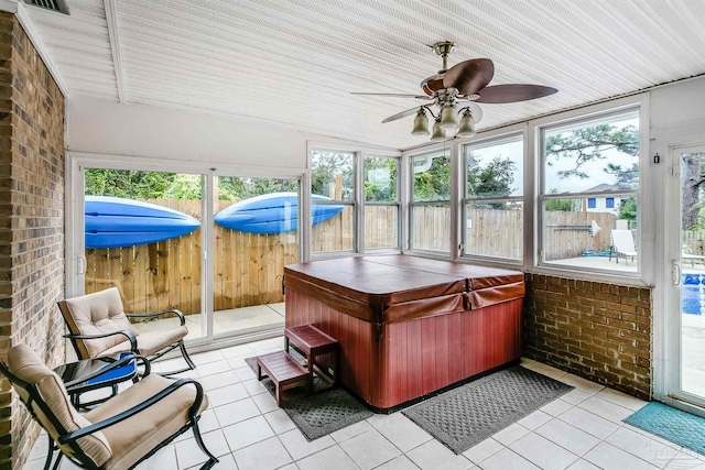 sunroom / solarium with a jacuzzi, plenty of natural light, and ceiling fan