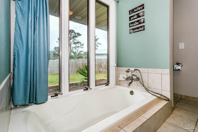 bathroom featuring tile patterned floors and a relaxing tiled tub