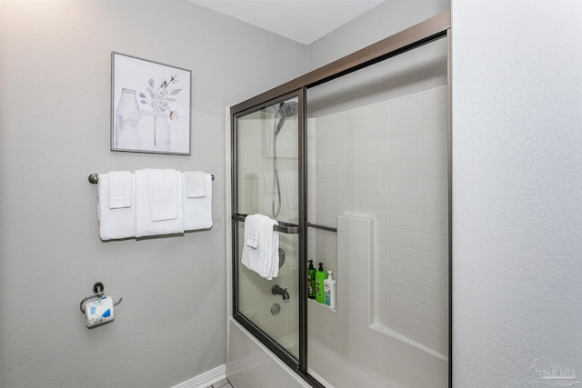 bathroom featuring bath / shower combo with glass door