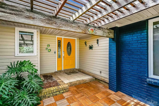 view of exterior entry featuring a pergola