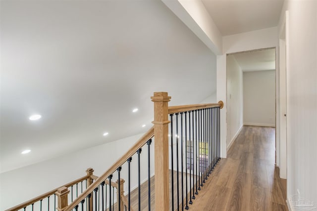 corridor featuring recessed lighting, an upstairs landing, and wood finished floors