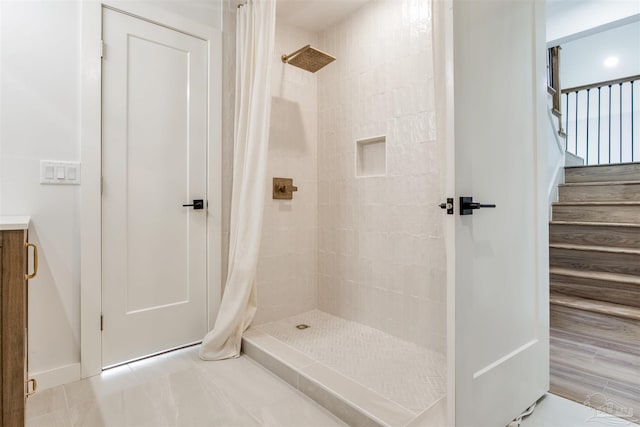 bathroom featuring baseboards and tiled shower