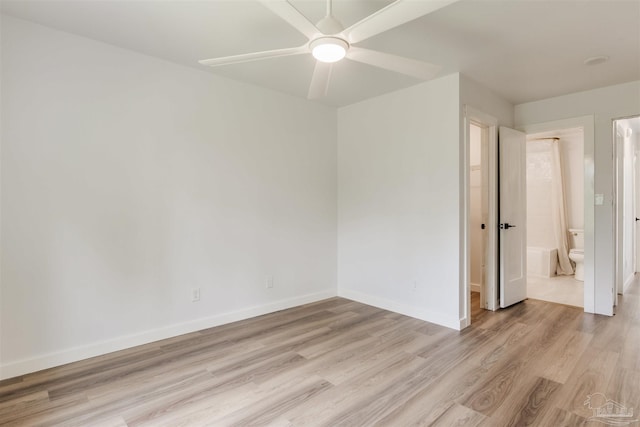 unfurnished bedroom with a ceiling fan, baseboards, ensuite bathroom, and light wood-type flooring