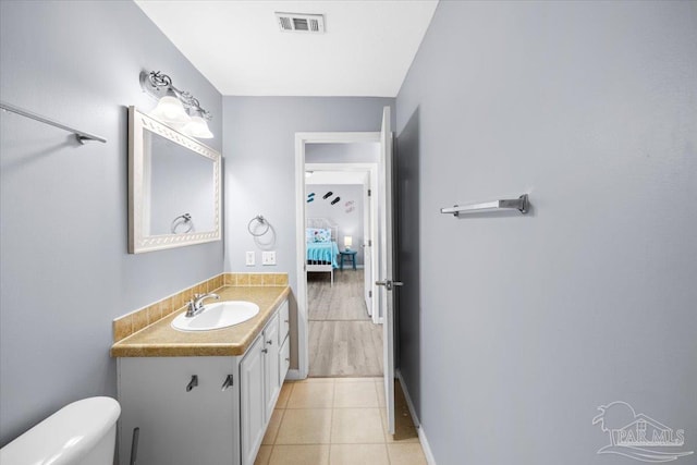 bathroom featuring tile patterned floors, vanity, and toilet