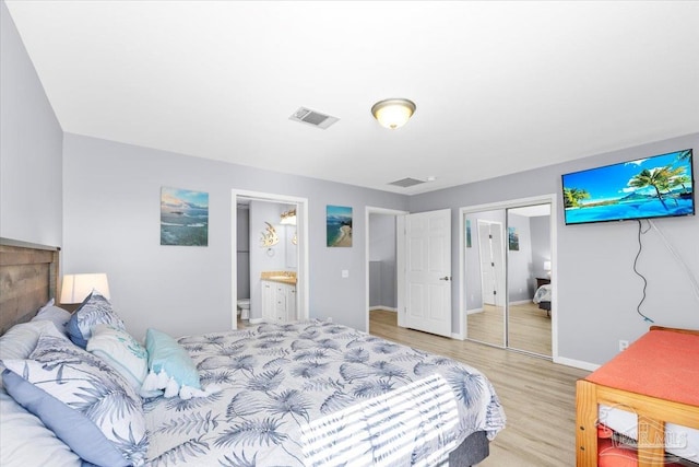 bedroom featuring ensuite bathroom, light hardwood / wood-style floors, and a closet