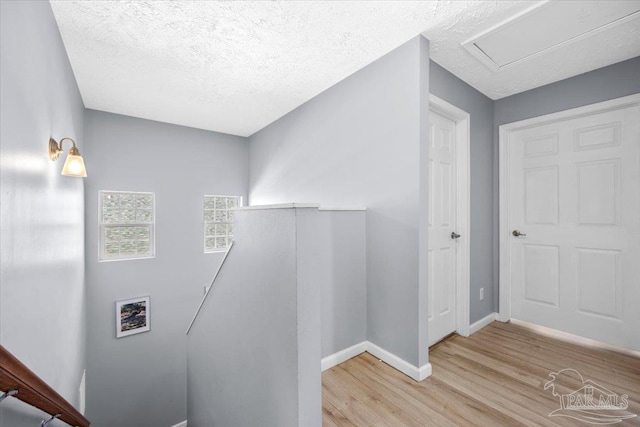 staircase featuring a textured ceiling and hardwood / wood-style flooring