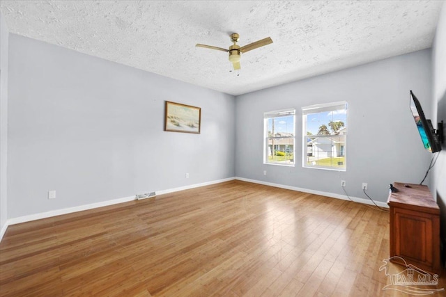 interior space with ceiling fan, a textured ceiling, and hardwood / wood-style flooring