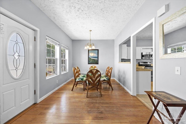 dining space featuring a chandelier, hardwood / wood-style floors, and a textured ceiling