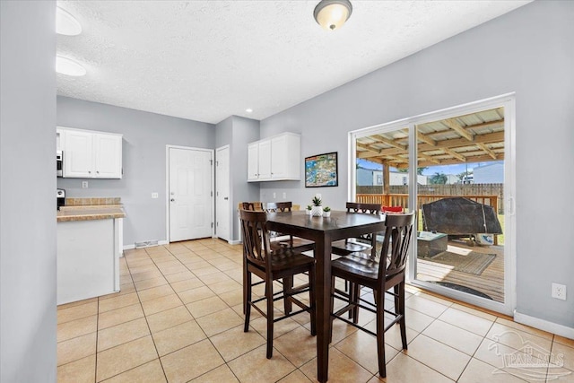 tiled dining room featuring a textured ceiling