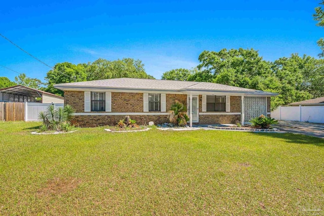 ranch-style home with brick siding, a front lawn, and fence