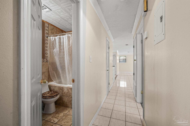 corridor with light tile patterned floors, ornamental molding, and visible vents