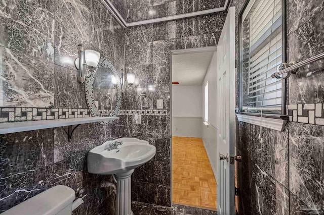 bathroom with toilet, tile walls, and a textured ceiling