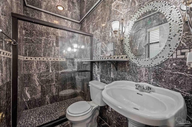 bathroom with a sink, toilet, tile walls, and a shower stall