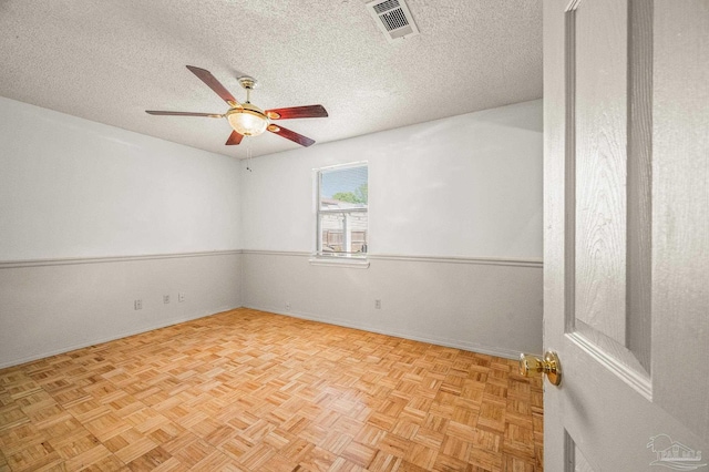 unfurnished room with a textured ceiling, baseboards, a ceiling fan, and visible vents