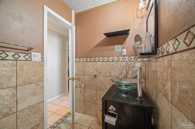 bathroom featuring wainscoting, vanity, tile walls, and tile patterned floors