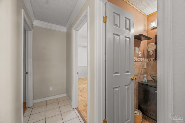 corridor with crown molding, a textured ceiling, and baseboards